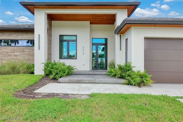 entrance to property with an attached garage, french doors, and stucco siding