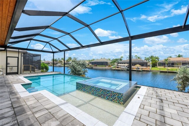 view of pool with a water view, a patio, a lanai, and an in ground hot tub