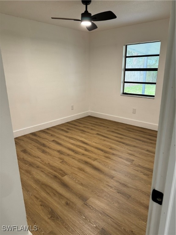 spare room with ceiling fan and dark hardwood / wood-style flooring