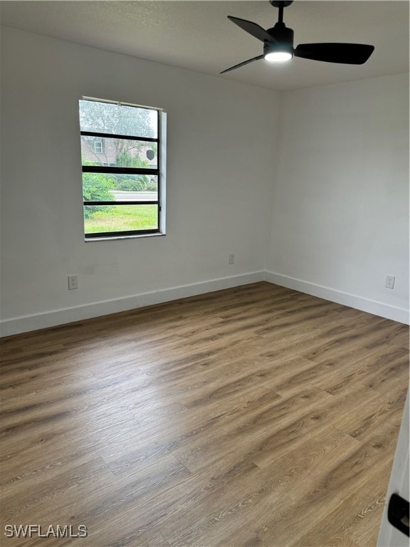 spare room featuring wood-type flooring and ceiling fan