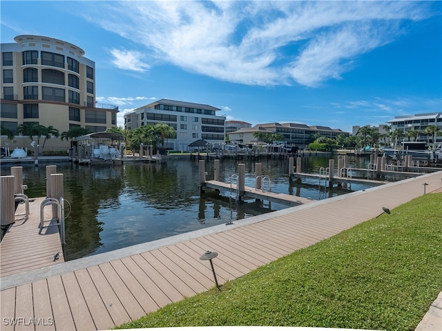 view of dock with a yard and a water view