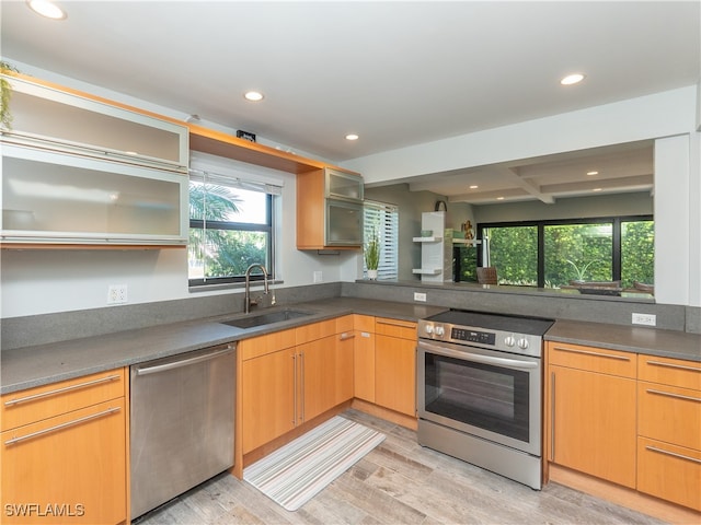 kitchen with beamed ceiling, stainless steel appliances, light hardwood / wood-style flooring, and sink