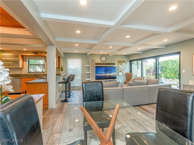 living room with beam ceiling, plenty of natural light, coffered ceiling, and light hardwood / wood-style flooring