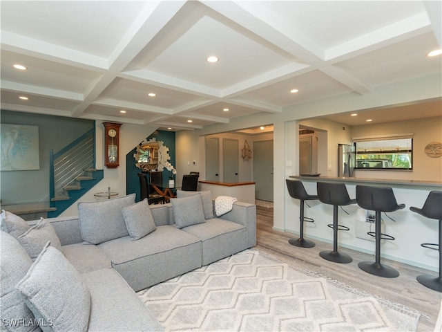 living room featuring beam ceiling, coffered ceiling, and light wood-type flooring