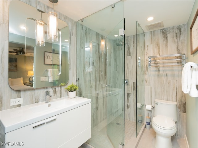 bathroom with vanity, ceiling fan, toilet, tile walls, and an enclosed shower