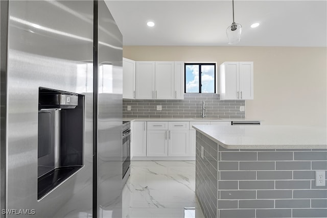 kitchen featuring sink, stainless steel fridge, and white cabinets