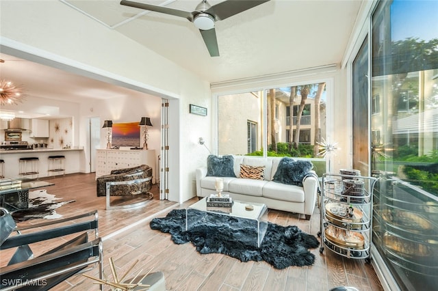 sunroom / solarium featuring ceiling fan with notable chandelier