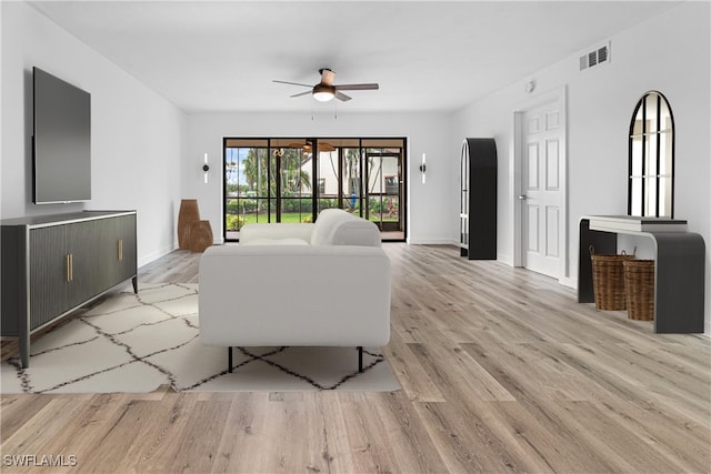 living room featuring ceiling fan and light hardwood / wood-style floors