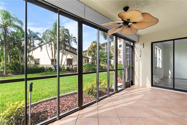 unfurnished sunroom featuring ceiling fan