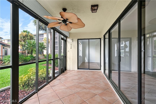 unfurnished sunroom with ceiling fan