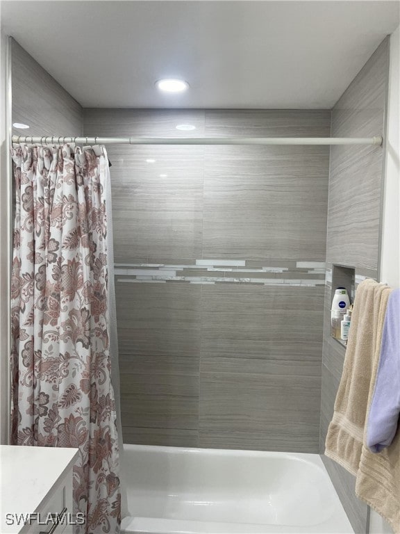 bathroom featuring vanity and shower / bath combination with curtain