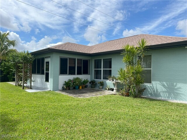 back of house featuring a lawn and a patio