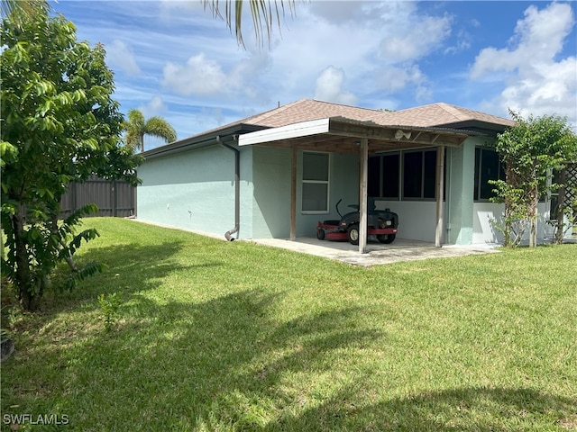 back of house featuring a lawn and a patio area