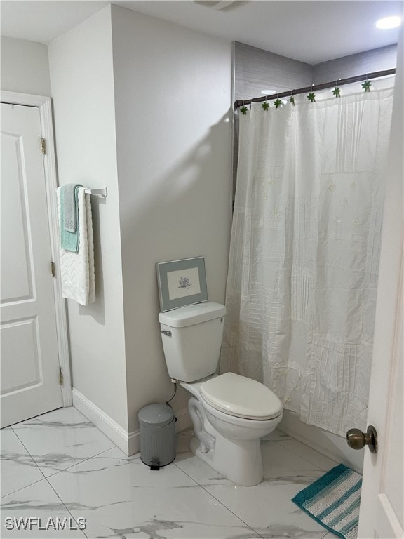 bathroom with a shower with curtain and toilet