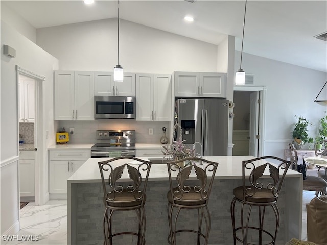 kitchen featuring a kitchen bar, stainless steel appliances, decorative backsplash, and vaulted ceiling