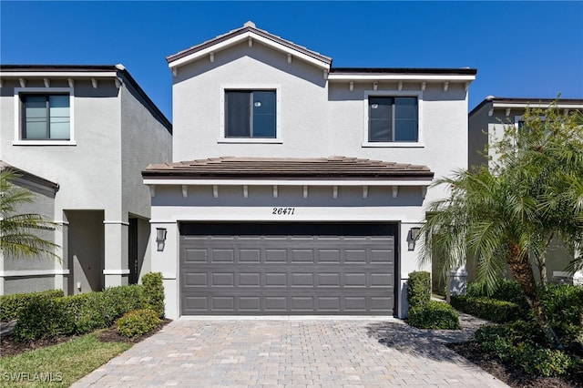 view of front of home with a garage, decorative driveway, and stucco siding