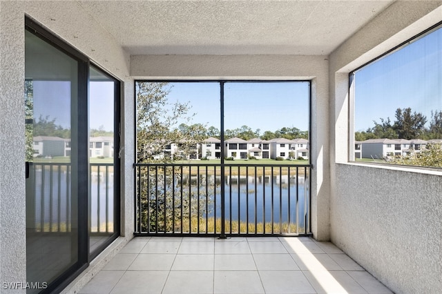 sunroom featuring a water view