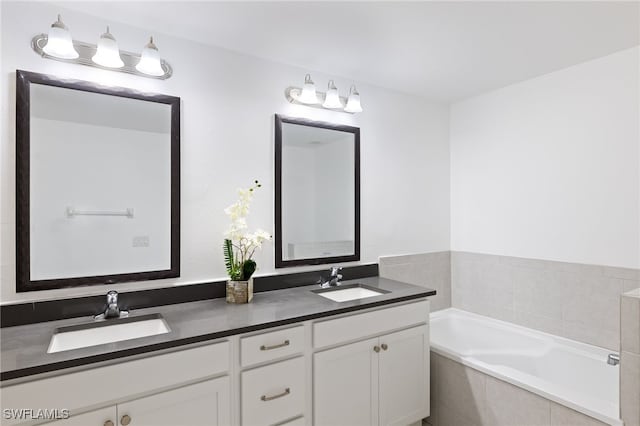 bathroom featuring vanity and tiled tub