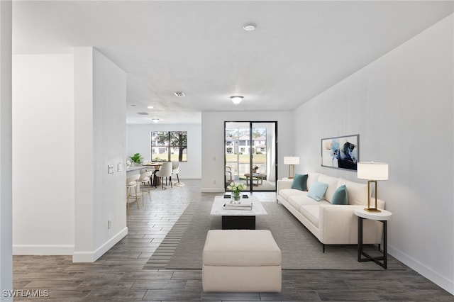 living room featuring wood tiled floor, visible vents, and baseboards