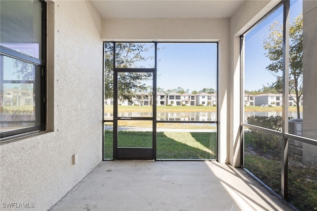 unfurnished sunroom with a water view