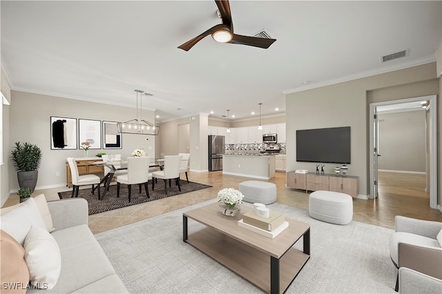 living room with light tile patterned floors, crown molding, and ceiling fan with notable chandelier