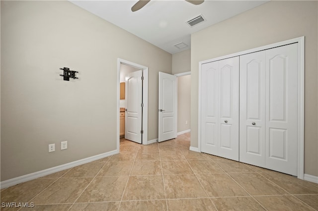 unfurnished bedroom with ceiling fan, a closet, and light tile patterned flooring