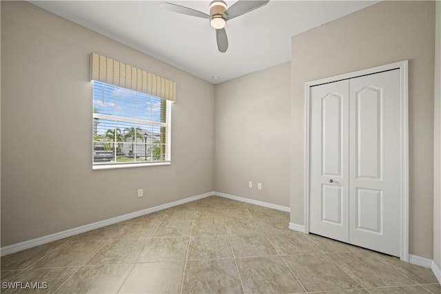 unfurnished bedroom with a closet, ceiling fan, and light tile patterned flooring