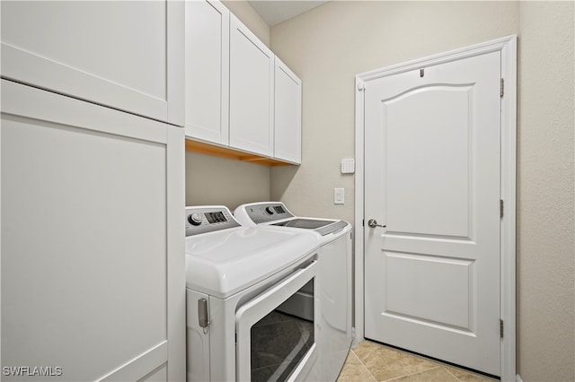 washroom with light tile patterned floors, cabinets, and independent washer and dryer