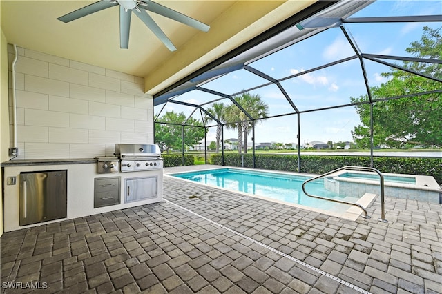 view of swimming pool with glass enclosure, exterior kitchen, area for grilling, ceiling fan, and a patio