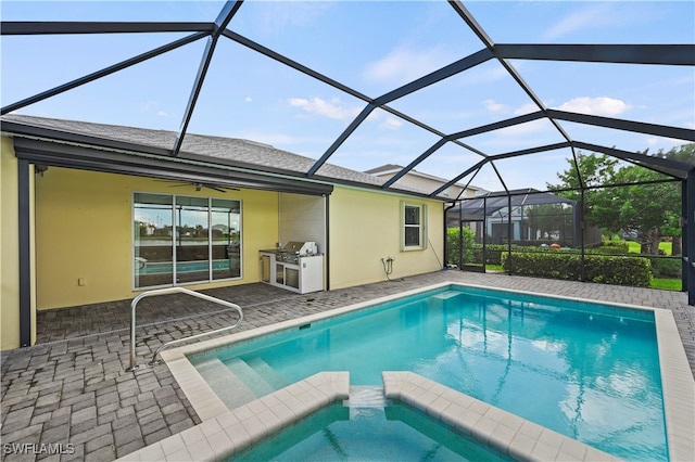 view of pool with glass enclosure and a patio