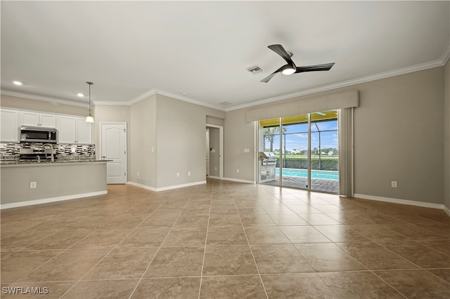 unfurnished living room featuring ceiling fan, light tile patterned floors, and crown molding