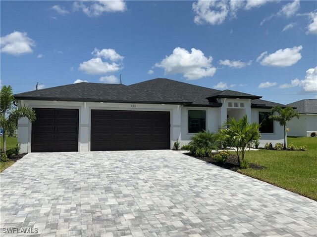 view of front of property with a garage and a front lawn