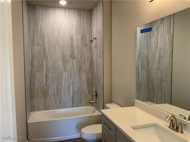 full bathroom with tiled shower / bath, vanity, and toilet