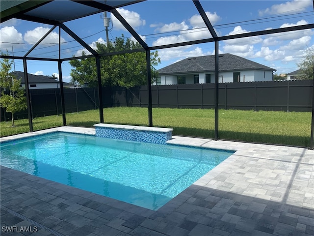 view of pool with a yard, glass enclosure, and a patio area