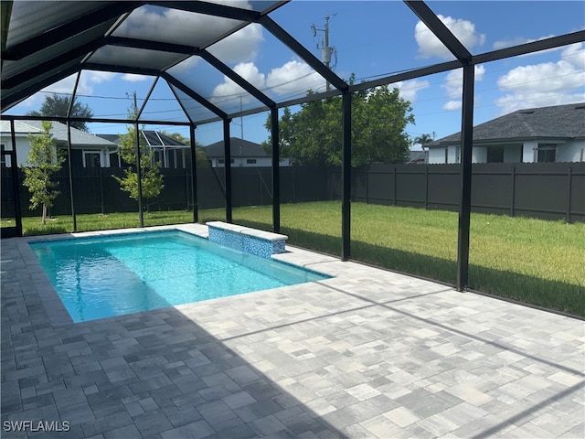 view of pool with glass enclosure, a patio area, and a lawn