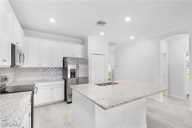 kitchen featuring sink, appliances with stainless steel finishes, light stone countertops, a kitchen island with sink, and white cabinets