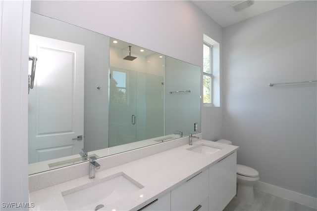 bathroom featuring vanity, toilet, and an enclosed shower