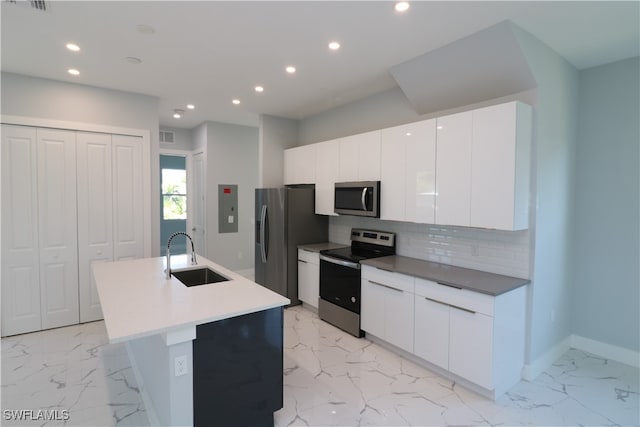 kitchen featuring white cabinetry, electric panel, an island with sink, sink, and appliances with stainless steel finishes