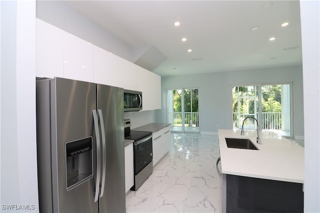 kitchen featuring stainless steel appliances, sink, and white cabinetry