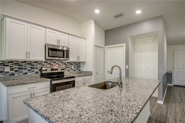 kitchen featuring dark hardwood / wood-style flooring, appliances with stainless steel finishes, an island with sink, and sink