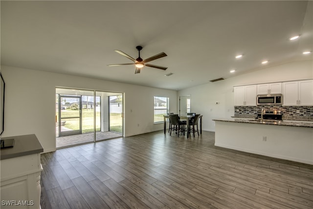 unfurnished living room featuring lofted ceiling, ceiling fan, and light hardwood / wood-style floors