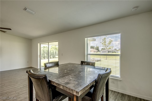 dining space with light hardwood / wood-style flooring and ceiling fan