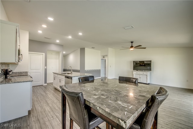 dining area featuring light wood-type flooring, sink, and ceiling fan