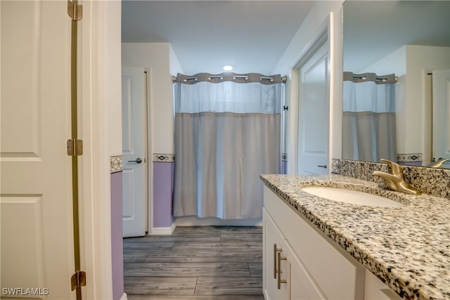 bathroom featuring hardwood / wood-style floors, walk in shower, and vanity