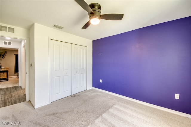 unfurnished bedroom with carpet, ceiling fan, and a closet