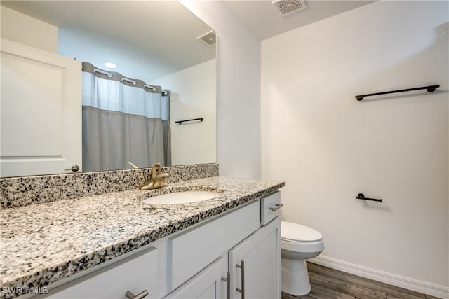 bathroom with a shower with shower curtain, vanity, toilet, and wood-type flooring