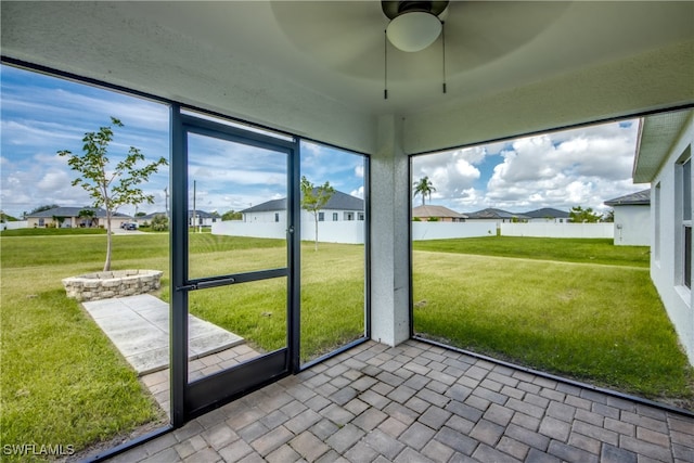 unfurnished sunroom with ceiling fan