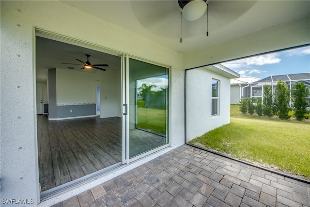 unfurnished sunroom featuring ceiling fan