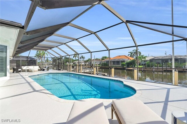 view of pool featuring a water view, glass enclosure, a boat dock, and a patio