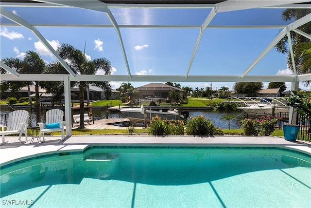 outdoor pool with a water view, glass enclosure, a patio area, a boat dock, and fence